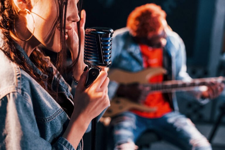 guy plays guitar girl sings african american man with white girl rehearsing studio together